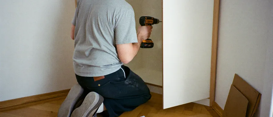 Handwerker baut ein Möbelstück in einer Wohnung auf